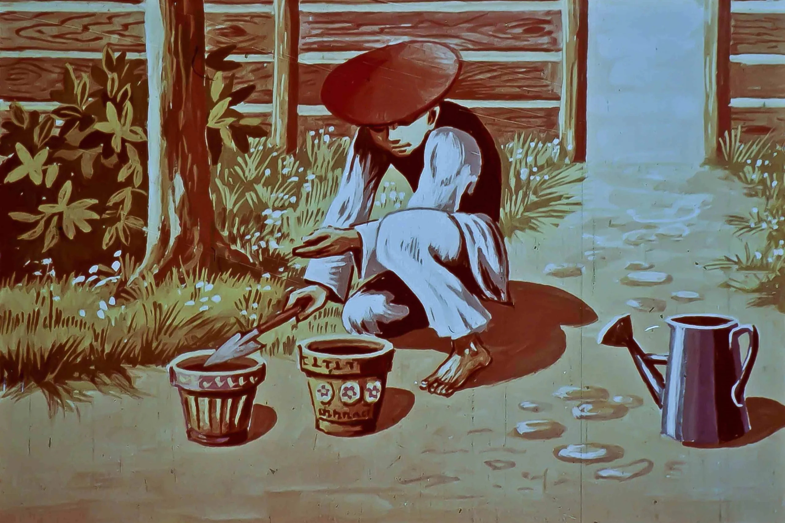 Imaginea arată un muncitor asiatic îmbrăcat în haine tradiționale, îngrijind plante într-o grădină, folosind un instrument de grădinărit, cu o găleată alături.