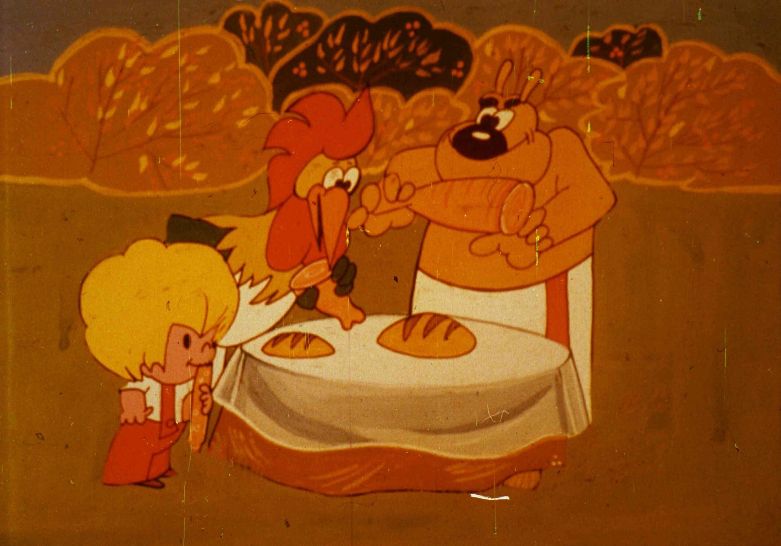 Imagine animată cu un pui, un câine și un copil, interacționând în jurul unei mese cu pâini, evidențiind importanța prieteniei și a mesei delicioase.