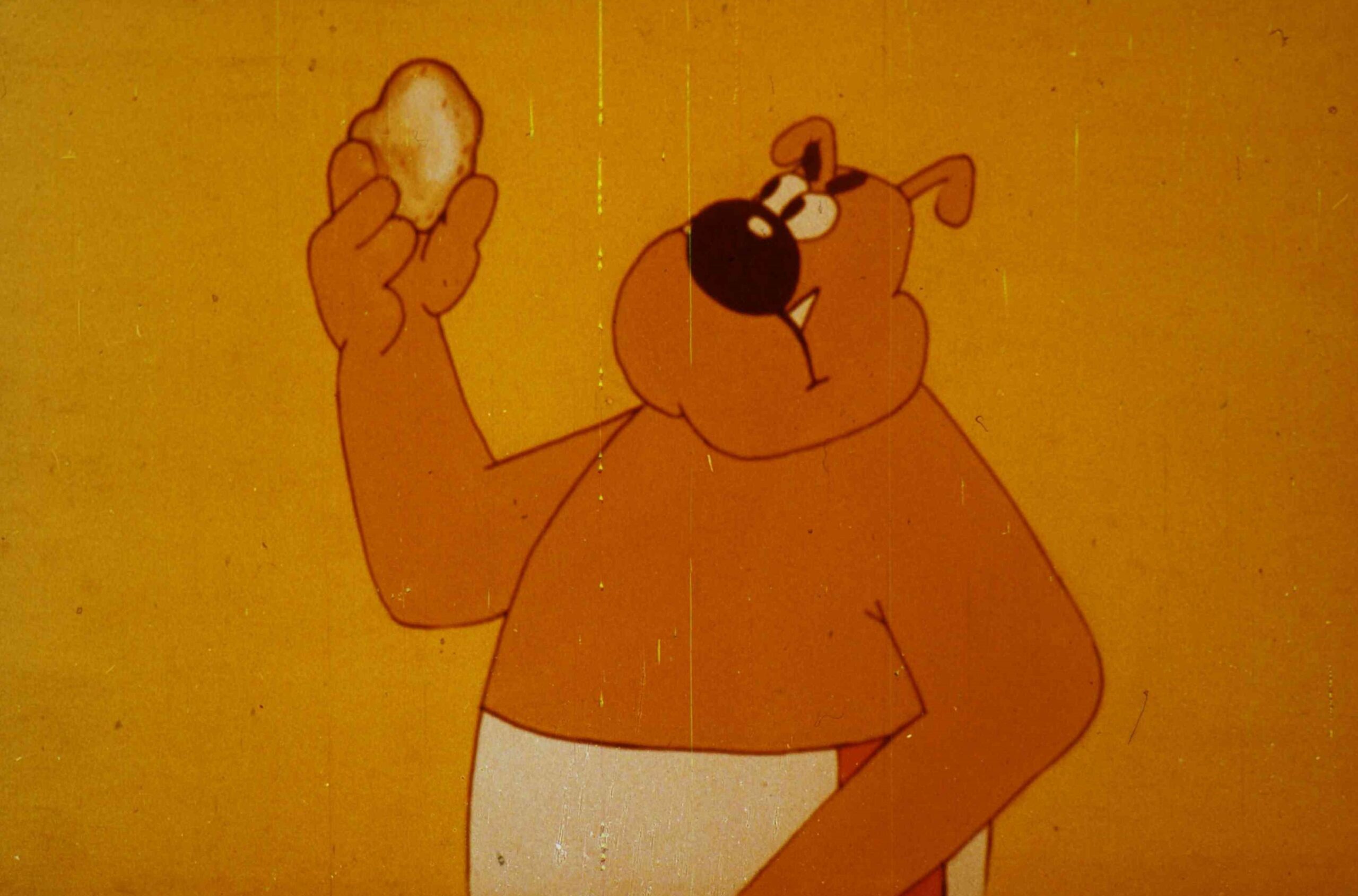 Un personaj animat ținând în mână un obiect rotund pe un fundal galben.