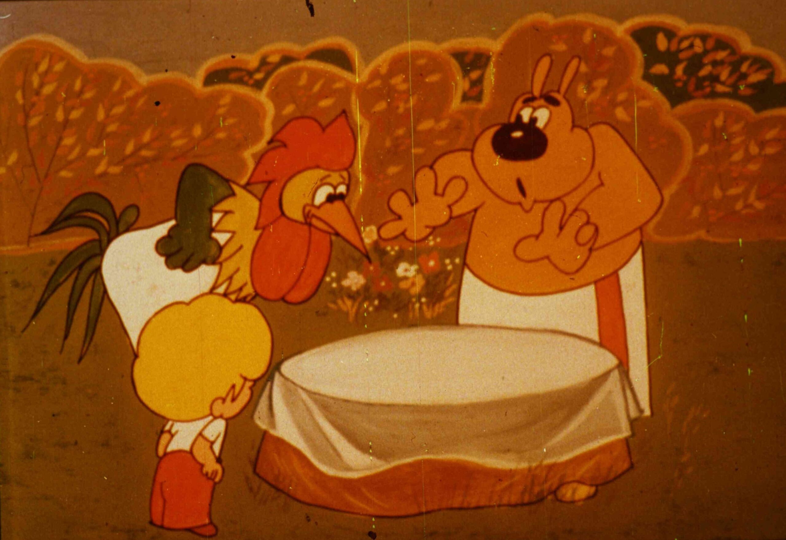 Imagine animată cu personaje care discută în jurul unei mese goale.