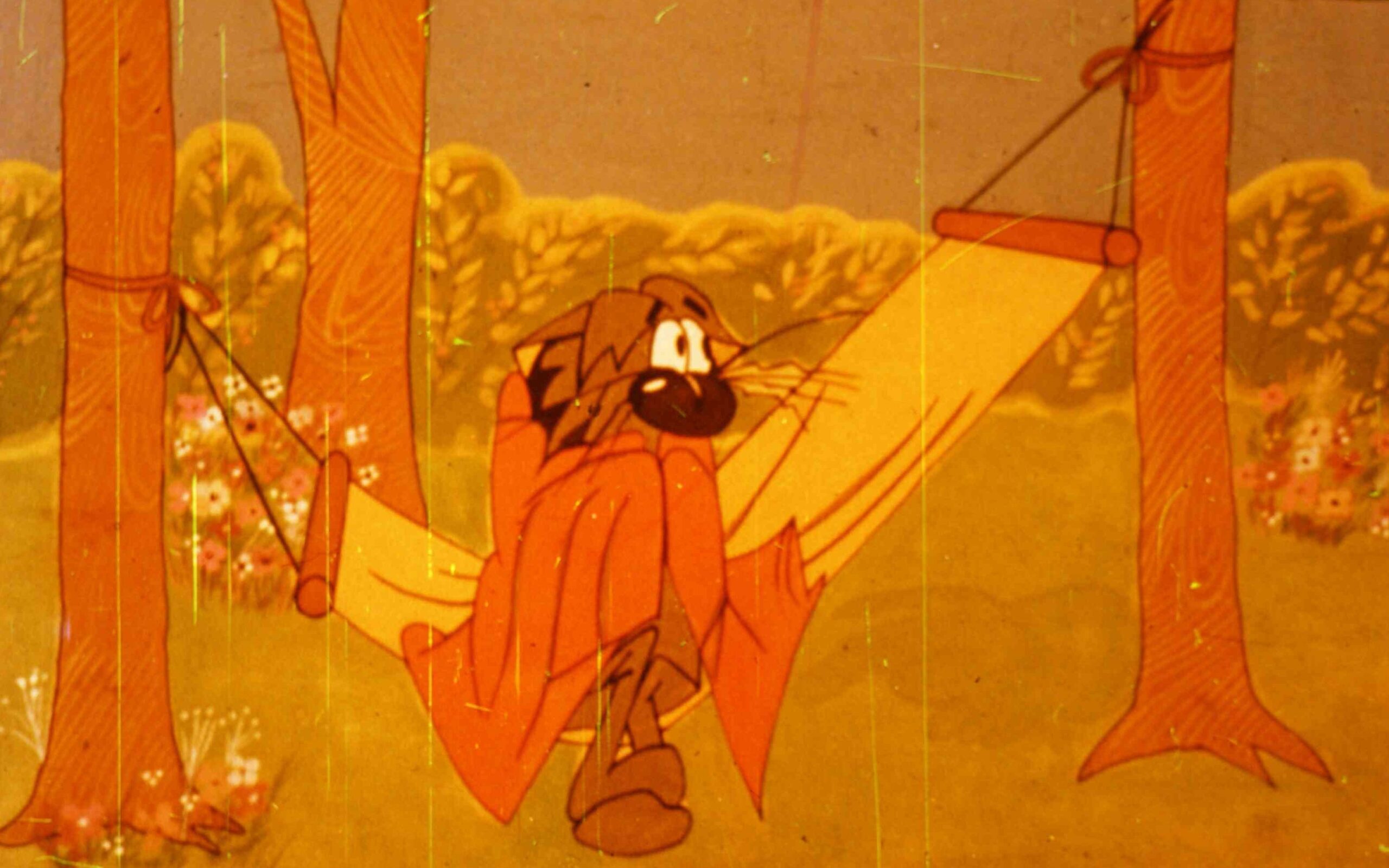 Un personaj animat care se odihnește într-un hamac, având o expresie relaxată, cu un fundal natural.