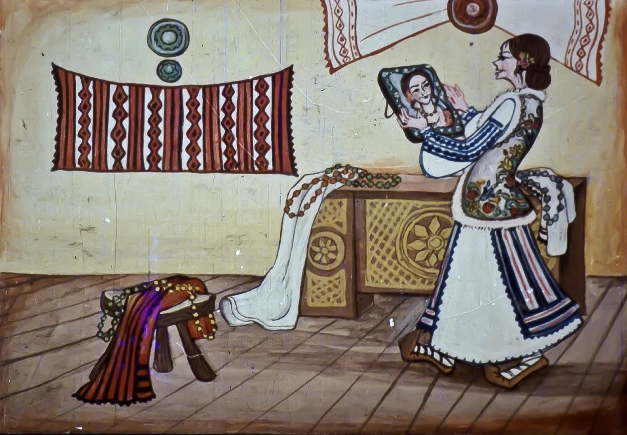 O femeie îmbrăcată în costum popular privește în oglindă, întrebând despre frumusețea ei.