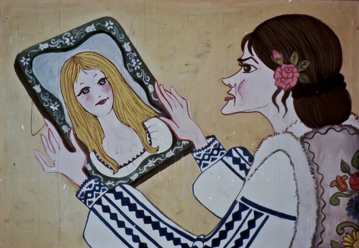 O femeie admirându-se într-o oglindă, menționând frumusețea unei alte femei numite Florita.