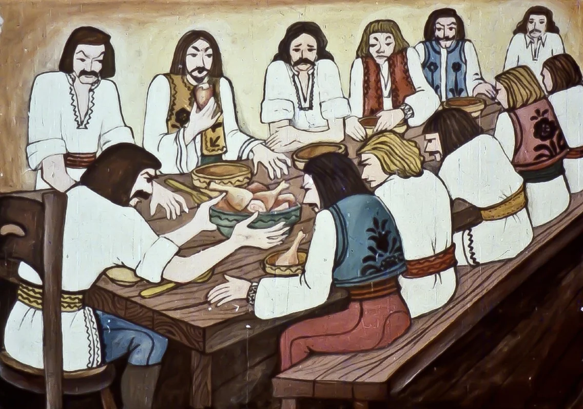 O scenă care ilustrează oameni aşezati la o masă, împărțind bucate.