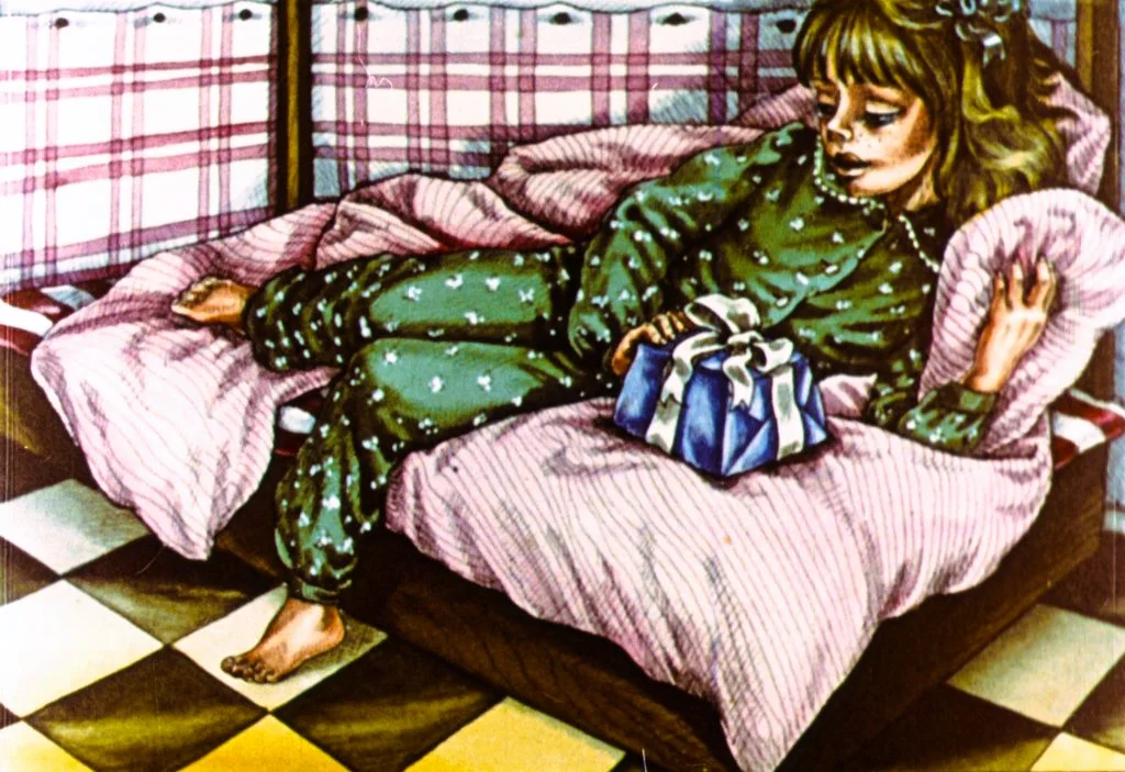 Un copil îmbrăcat în pijama stă întins pe o canapea cu o cutie de cadou în brațe, într-o cameră decorată cu un model de pătură cu carouri.