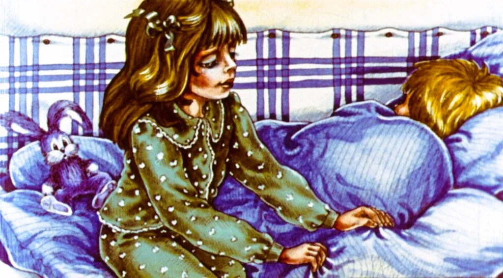 O fetiță cu păr lung și castaniu stă pe o canapea, îmbrăcată într-o pijama verde cu buline, atingând ușor un băiețel acoperit cu o pătură albastră. În apropiere se află un iepure de pluș.