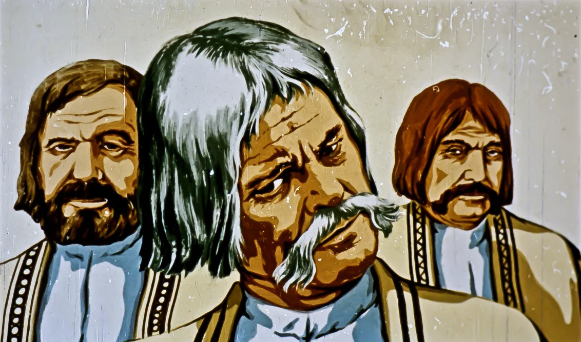 O ilustrație colorată ce prezintă trei bărbați cu barbă, îmbrăcați în costume tradiționale, într-un fundal simplu.