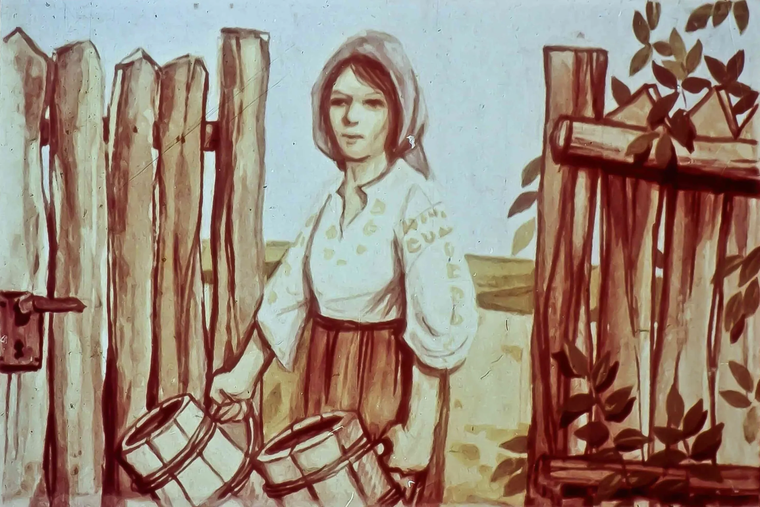 O femeie care poarta un costum traditional si tine in maini doua balti, in fata unui gard din lemn.