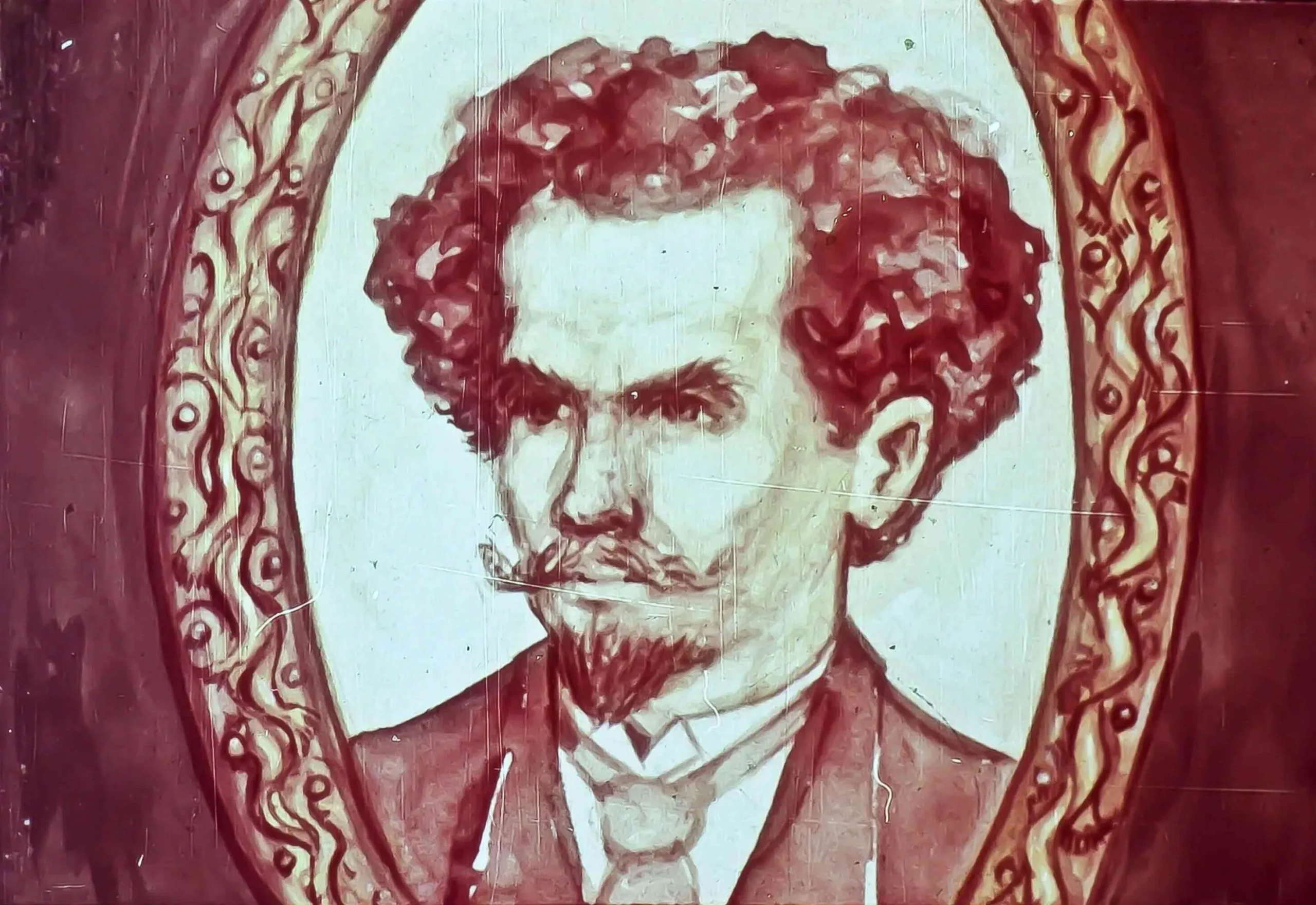 Oil painting of a man with curly hair and a mustache, framed in an ornate border.