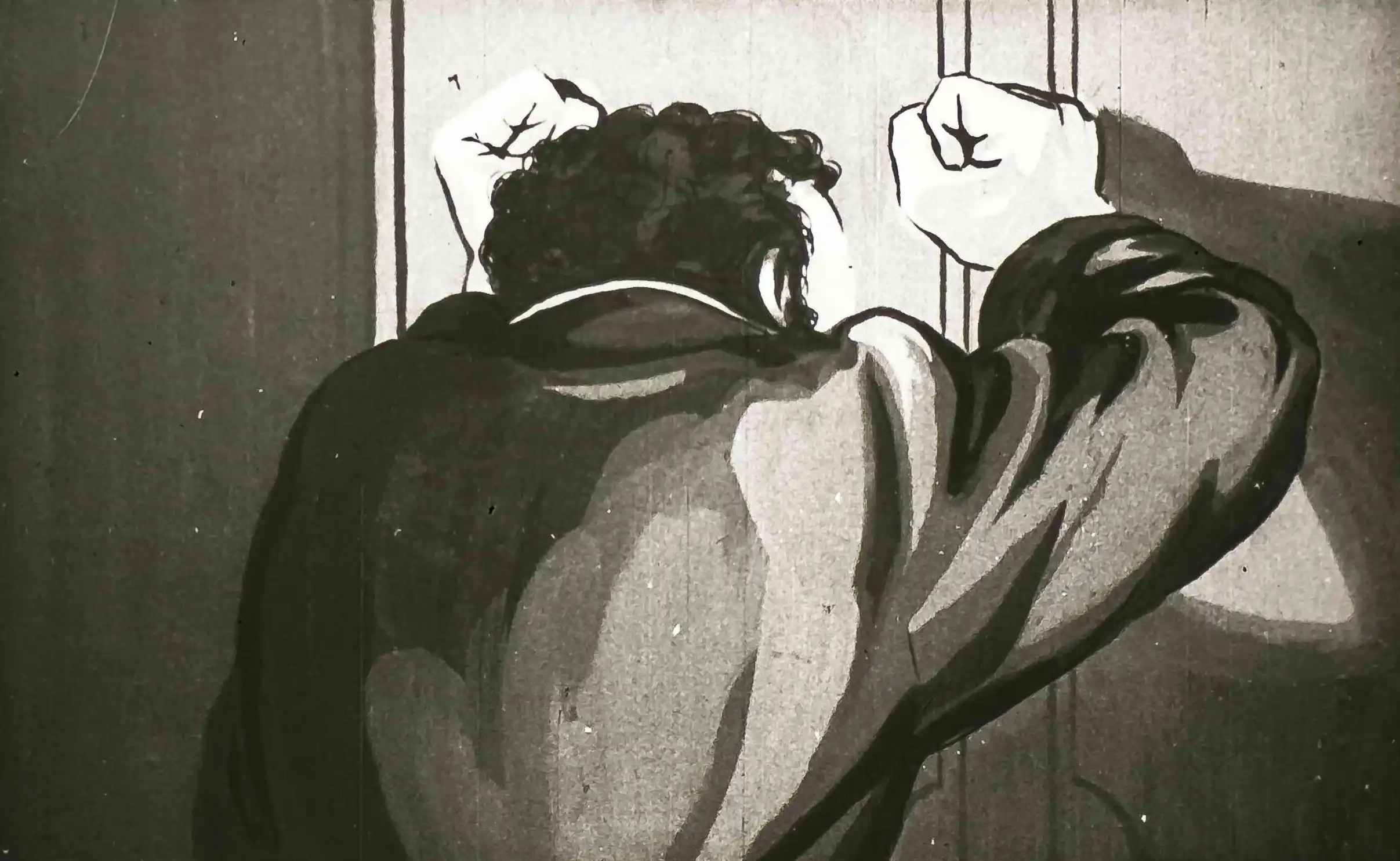 Imagine alb-negru cu un bărbat cu părul rebel, îmbrăcat cu un palton, care își lovește pumnii în ușa unei cabine.